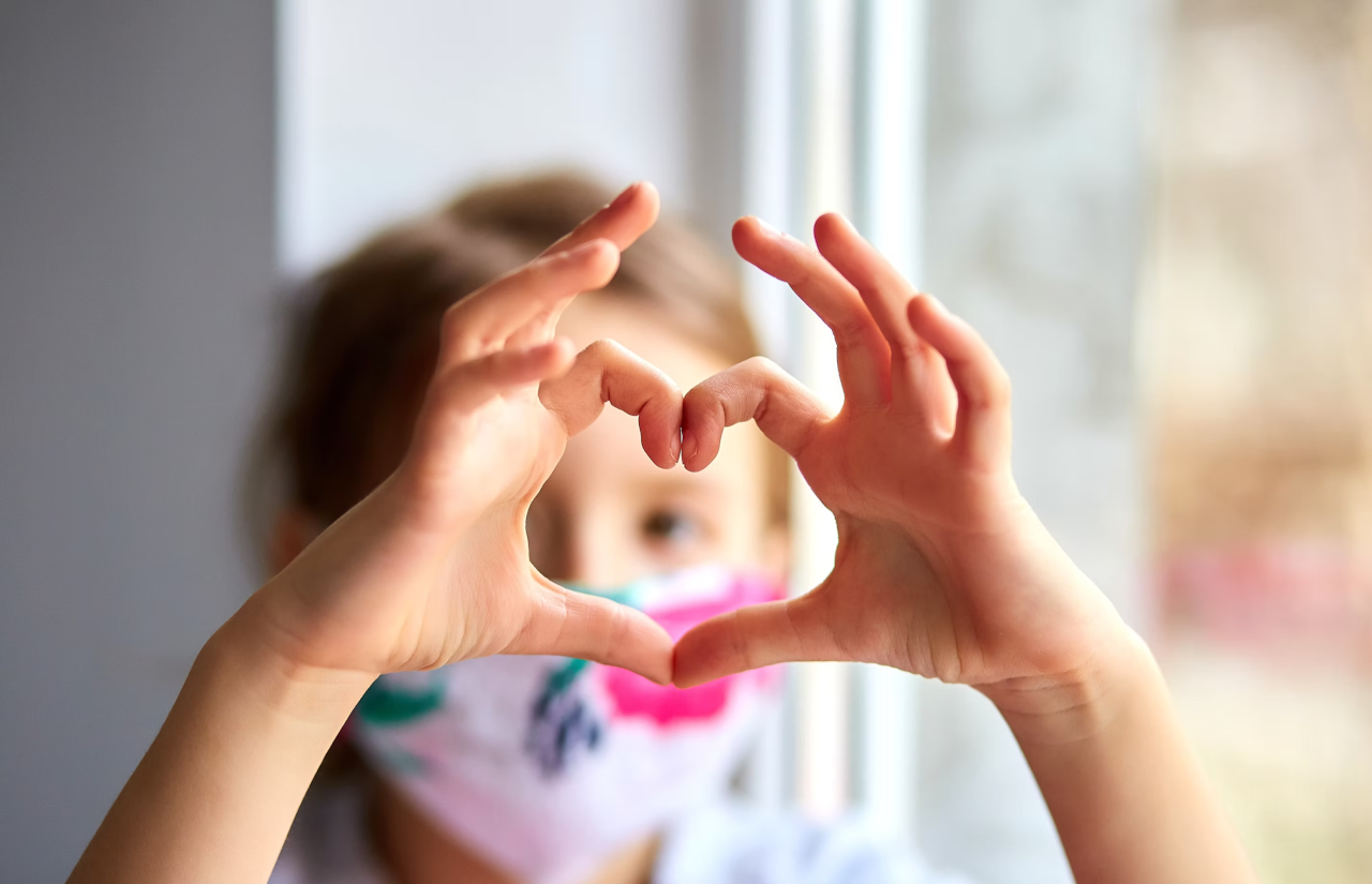 Niño haciendo corazón con las manos